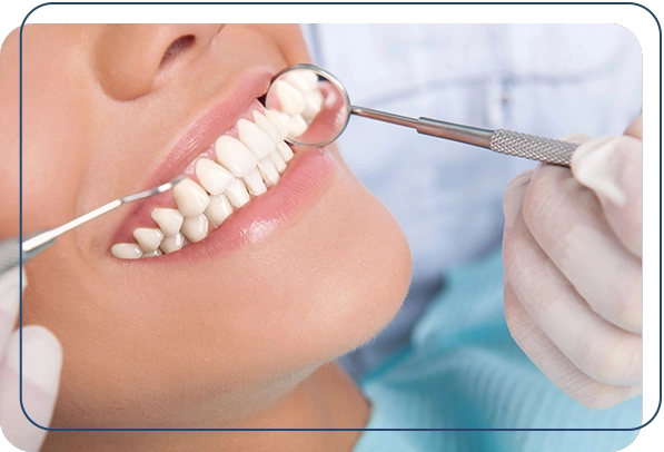 A woman getting her teeth cleaned by dentist.