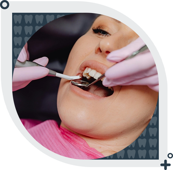 A woman is getting her teeth cleaned by dentist.